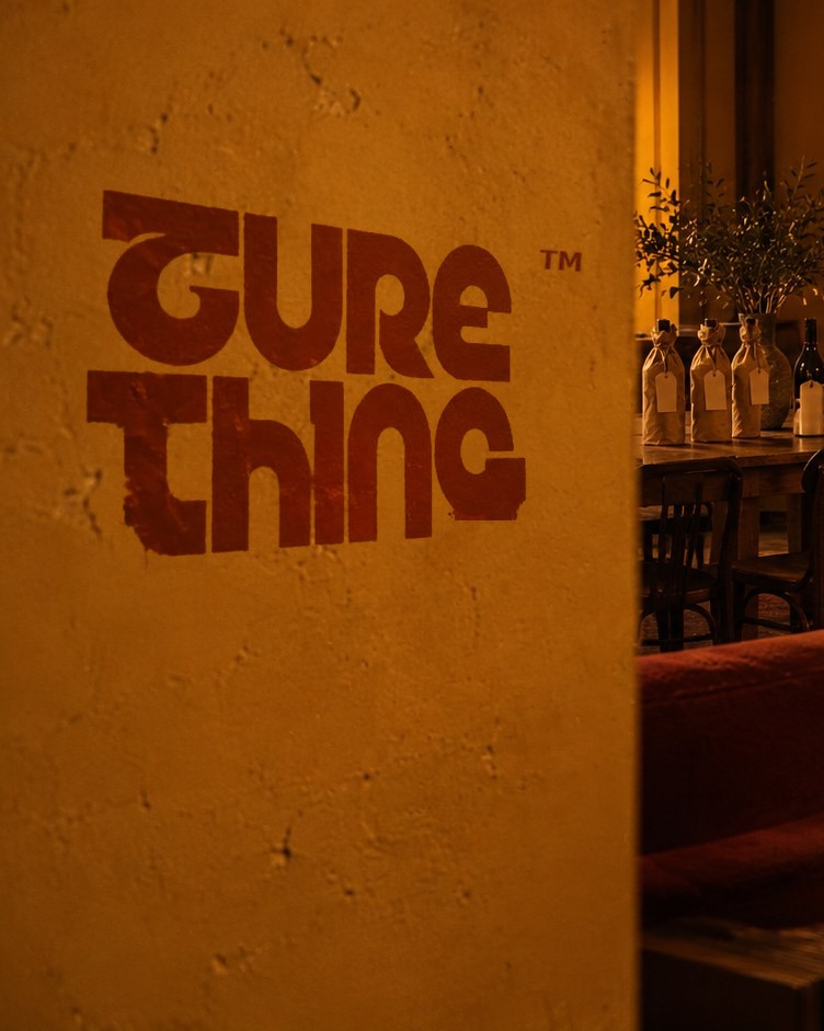 Sure Thing-ի լոգոն՝ նկարված օխրա պատին